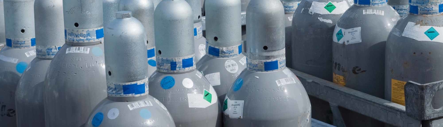 several racks of grey industrial-sized gas canisters