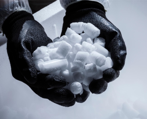 Image of a person handling dry ice with thick rubber gloves