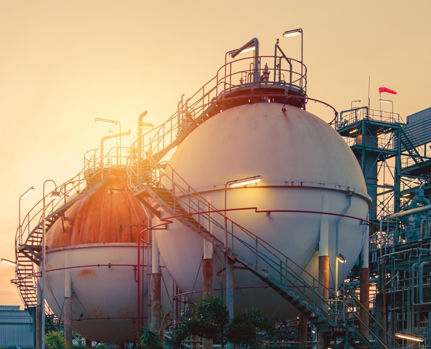 sideview of gas storage tanks at sunset