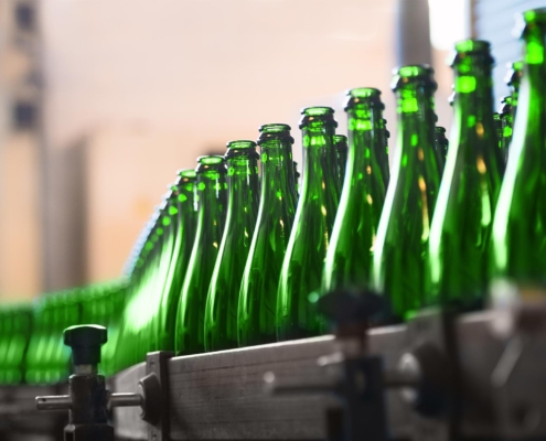 A row of green bottles on a production line