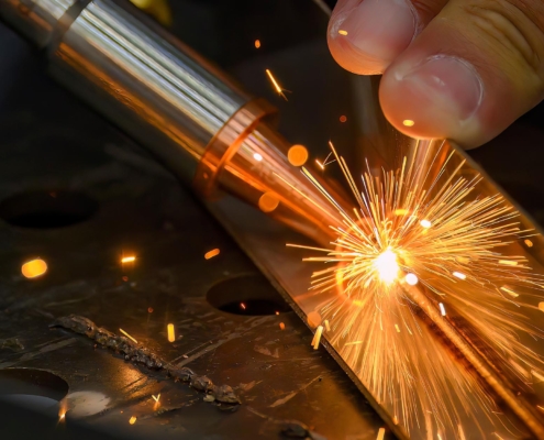 Worker using laser welder on two metal pieces