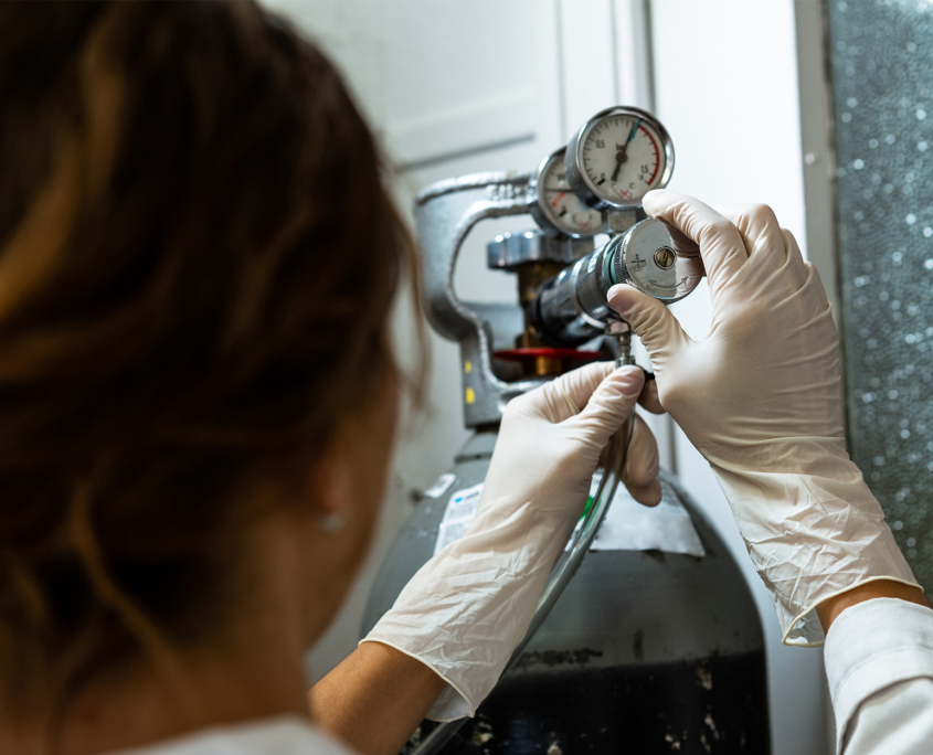 Female Technician In Gloves Adjusting A Barometer Of A Nitrogen Cylinder