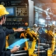 welding operator reviewing welding robotic arm performance on a screen