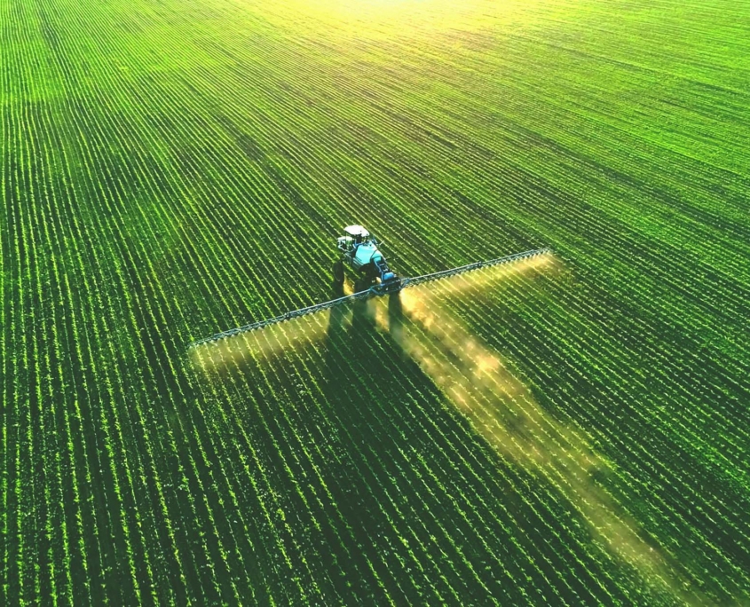 Tractor Spray Fertilizer On Green Field Drone High Angle View